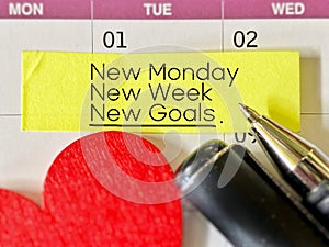 Inspirational and Motivational Concept - New monday new week new goals text on yellow notepaper background. Stock photo.