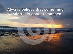 Inspirational motivational quote - Always believe that something wonderful is about to happen. With blurry image of beach.