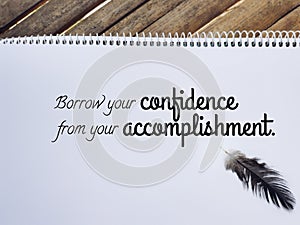Inspirational and motivational quote - borrow your confidence from your accomplishment. Stock photo.
