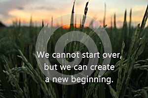 Inspirational motivational quote-we cannot start over, but we can create a new beginning. With blurry colorful sunrise light in