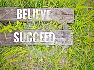 Inspirational motivational quote concept - Believe succeed on wooden plank with nature background.