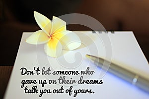 Inspirational motivational quote - Do not let someone who gave up on their dreams talk you out of yours. Message on notebook.