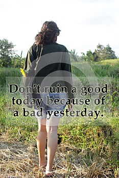 Inspirational motivational quote - Do not ruin a good today because of a bad yesterday. With young woman walking on field