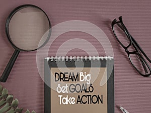 Inspirational and motivational quote of dream big set goals take action on notepaper in vintage background