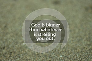 Inspirational motivational quote - God is bigger than whatever is stressing you out. With blurry black sands pattern texture.