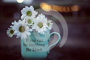 Inspirational motivational quote - If you can be anything. Be kind. With cup of coffee or tea with white daisy flowers.