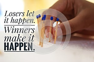 Inspirational motivational quote - Losers let it happen. Winners make it happen. With background of hand holding matches. photo