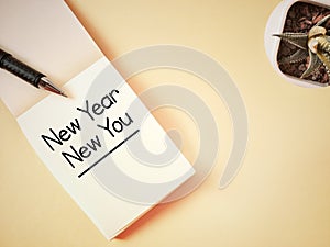 Inspirational and motivational quote - new year new you text written on notepad background. Stock photo.