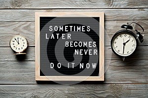 Inspirational motivational quote Sometimes later becomes never. Do it now words on a letter board on wooden background near