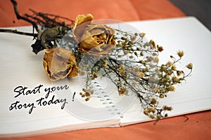 Inspirational words - Start your story today. Notes on a notebook concept with dried roses flowers.