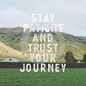 Inspirational motivational quote `stay patient and trust your journey.` with mountain view background.