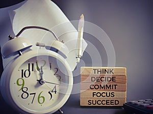 Inspirational and motivational quote of think decide commit focus succeed text on wooden blocks in vintage background. Stock photo