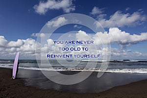Inspirational motivational quote- You are never too old to reinvent yourself. With blurry image of a young surfer girl standing