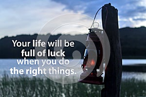 Inspirational motivational quote - Your life will be full of luck when you do the right things. With oil lantern hanging on wood.