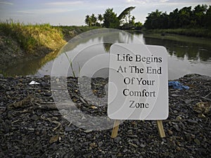 Inspirational motivational quotes written on white board with nature background. Life begins at the end of your comfort zone