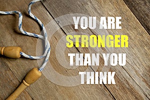 Inspirational motivational quotes You Are Stronger Than You Think on wooden background. Health and fitness concept.