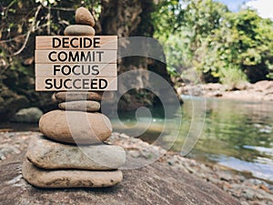 Inspirational and motivational words of decide commit focus succeed on wooden blocks background.
