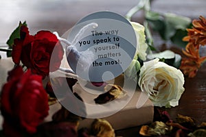 Inspirational motivational words - The way you speak to yourself matters the most. Note to self concept on paper label with roses.