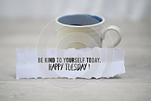 Inspirational quote - Be kind to yourself today. Happy Tuesday. With a cup of morning coffee and a white paper note concept.l