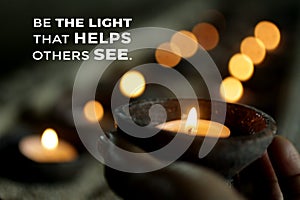 Inspirational quote - Be the light that helps others see. Be inspire and kindness concept with person holding a candle light.