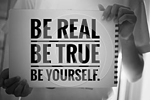 Inspirational quote - Be real. Be true. Be yourself. With young girl holding white paper book sign with reminder notes.