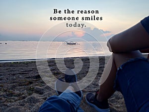 Inspirational quote - Be the reason someone smiles today. With blurry image of two best friends together sitting on sands enjoying