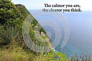 Inspirational quote - The calmer you are, the clearer you think. With view of the sea from a cliff surrounded by green plants. photo