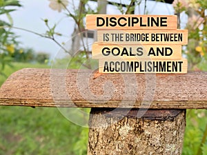 Inspirational Quote Concept - Discipline is the bridge between goals and accomplishment with blurry nature background.