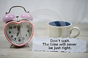 Inspirational quote - Do not wait. The time will never be just right. With alarm table clock and a cup of morning coffee.