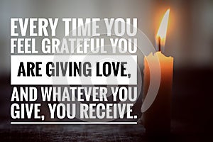 Inspirational quote - Every time you feel grateful you are giving love, and whatever you give, your receive. With a burning candle photo