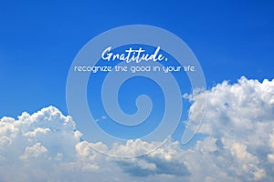 Inspirational quote - Gratitude, recognize the good in your life. On background of bright blue sky and white clouds.