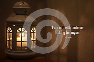 Inspirational quote - I am out wit lanterns, looking for myself. -Emily Dickinson. With old lantern on the table and its shadow. photo