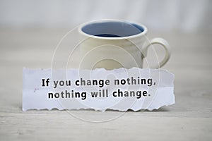 Inspirational quote - If you change nothing, nothing will change. With a cup of morning coffee and a white paper note concept.