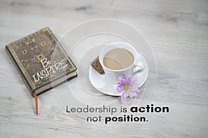 Inspirational quote - Leadership is action not position. Business concept with motivational words, a cup of morning coffee on desk