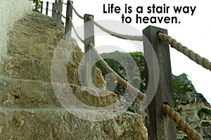 Inspirational quote - Life is a stair way to heaven. With natural wooden fence and stairs in the cliff background.