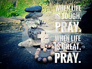 Inspirational quote - When life is tough, pray. When life is great, pray. With stone balance formation, Jesus Christ holy cross.