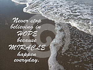 Inspirational quote- Never stop believing in HOPE because MIRACLES happen everyday. With waves flow pattern on black sands in the photo
