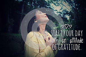 Inspirational quote - Start your day with an attitude of gratitude. Woman in the park with hands on chest.