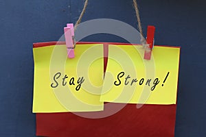 Inspirational quote - Stay strong. With origami paper notes hanging on wall. Encouragement concept with colorful creative papers.
