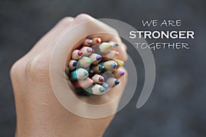Inspirational quote - We are strong together. With Bunch of colored pencils in hand. photo