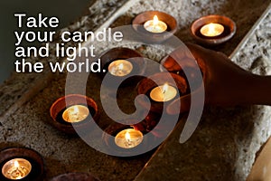 Inspirational quote - Take your candle and light the world. Motivational words with candles light on ceramic bowl.