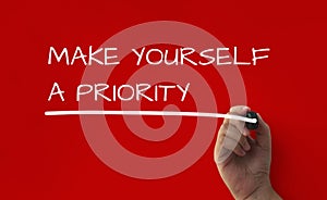 Inspirational quote text on red cover background - Make yourself a priority.