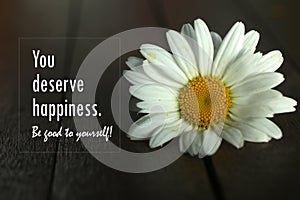 Inspirational quote - You deserve happiness. Be good to yourself.  Self love and care concept with background of white flower. photo