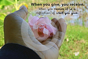 Inspirational quote - When you give, your receive. With woman holding pink flower in hand.