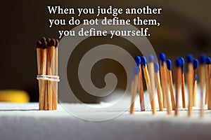 Inspirational quote - When you judge another, you do not define them, you define yourself. With background of colorful matches. photo