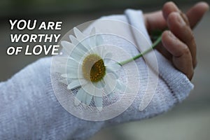 Inspirational quote - You are worthy of love. Words of wisdom about self love and care concept on background of white daisy flower photo