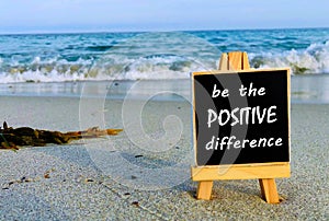 Inspirational quotes on black board - Be the positive difference.