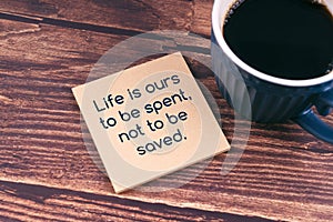 Inspirational quotes Life is ours to be spent, not to be saved text on adhesive note and cup of coffee