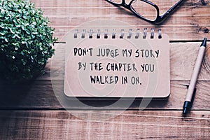Inspirational quotes on a notepad - Don`t judge my story by the chapter you walked in on . Blurry retro style