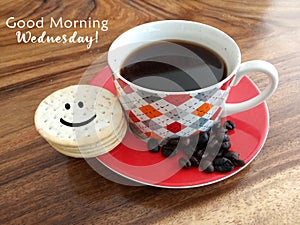 Inspirational text greeting - Good morning Wednesday. On background of a cup of black coffee, coffee beans and a cute smiling face